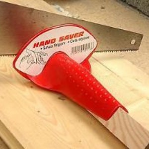 May include: Red plastic hand saw safety guard with the text "HAND SAVER" printed on it. The guard is designed to protect fingers from being cut by the saw blade.