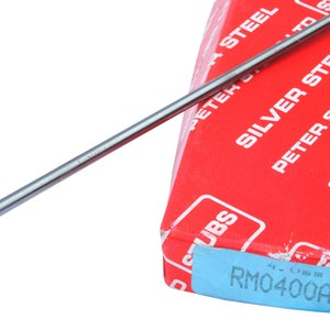 May include: A silver steel rod with a rounded end, resting on a red box with the text "SILVER STEEL PETER STUBS LTD" and "RM0400AK".