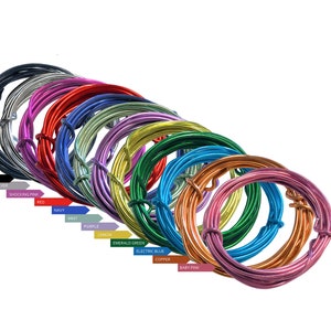 May include: A collection of 12 spools of colorful, metallic wire. The wire is arranged in a rainbow pattern, starting with black and ending with baby pink. Each spool is labeled with the color of the wire.