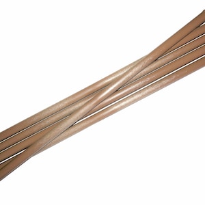 May include: A set of six brown wooden dowels with rounded ends. The dowels are arranged in a criss-cross pattern.