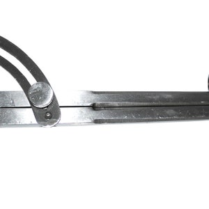 May include: A silver metal compass with a black handle and a knob on the top. The compass is used for drawing circles and arcs.