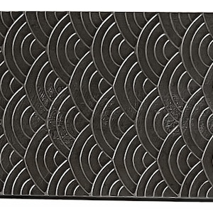 May include: A black rectangular tray with a raised, textured pattern of overlapping circles. The pattern resembles scales or waves.