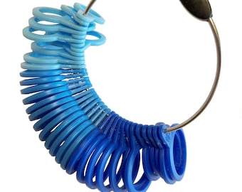 May include: A ring sizer tool with a series of blue plastic rings attached to a metal hoop. The rings graduate in color from light to dark blue. A black oval piece connects the hoop.