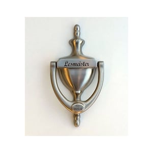 May include: A silver door knocker with a rectangular nameplate that reads "Lesmeister" and a round plaque that reads "Est. 2014".