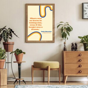 Könnte beinhalten: Ein gerahmter Druck mit gelbem Hintergrund und einem abstrakten Design in Blau, Orange und Gelb. Der Druck zeigt ein Zitat von John Mellencamp: "Es war kein Schaden, zu zielen, selbst wenn das Ziel ein Traum war."