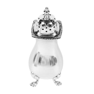 May include: A silver salt shaker with a decorative, perforated lid and a small finial. The shaker has a bulbous body and rests on three small, ornate feet. The design is classic and elegant, suitable for formal dining.