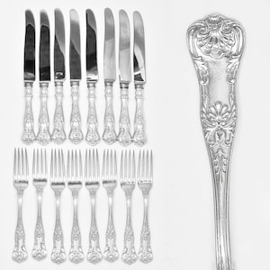May include: A set of silver flatware, including knives and forks, with ornate handles. The handles feature a floral design.