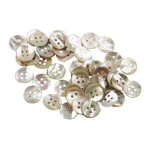 May include: A collection of iridescent, pearlescent buttons with four holes each. The buttons are round and have a subtle sheen, reflecting light with a range of colors. These buttons are ideal for sewing and craft projects.