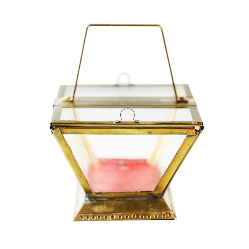 May include: A vintage-style lantern with a brass frame and clear glass panels. The lantern has a hinged lid and a handle for carrying. The interior features a red base. The lantern is designed with a geometric shape.