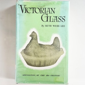 May include: A green book cover with the title "Victorian Glass" by Ruth Webb Lee. The book cover features a black and white illustration of a ceramic chicken in a nest. The text "Specialties of the 19th Century" is printed at the bottom of the cover.