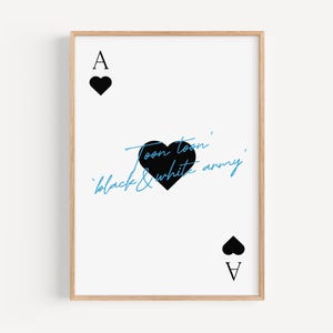 May include: A framed print featuring the Ace of Hearts playing card design. The card has a white background with black heart symbols and the text "Toon toon' black & white army" in black and blue script.