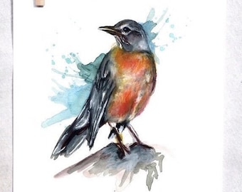 May include: Watercolor painting of a robin perched on a branch with blue and green watercolor splatters in the background.