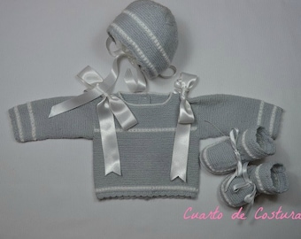 Pattern for a three-piece set (sweater, hat and boots) with "granite" stitches on the sleeves and front.