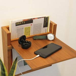 Wandmontierter Zeitschriftenständer mit Holzablage. Wandmontierter Zeitschriften- und Zeitungshalter mit ausziehbarem Regalboden.