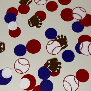 May include: A collection of red, white, and blue baseball-themed confetti. The confetti includes baseballs, baseball gloves, and circles.
