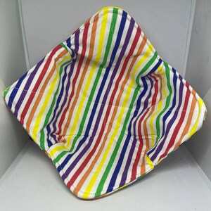 May include: A rainbow striped fabric bowl, perfect for holding small items or serving snacks. The bowl is made of a soft, quilted fabric and has a white background with colorful stripes.