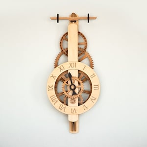 May include: A wooden clock with a unique design featuring gears and a pendulum. The clock face has Roman numerals and black hands.