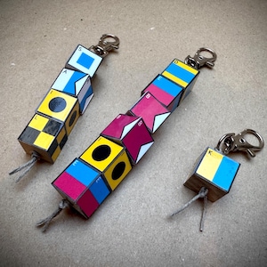 May include: A set of three ceramic mugs with a speckled, matte finish. The mugs are in shades of cream, light gray, and dark gray. Each mug has a simple, minimalist design, perfect for coffee or tea.