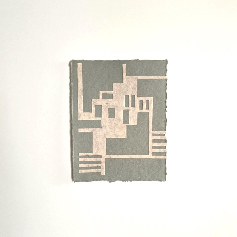 Puede incluir: Una peque&ntilde;a obra de arte rectangular con un dise&ntilde;o geom&eacute;trico. La obra de arte tiene un fondo gris claro con un patr&oacute;n geom&eacute;trico m&aacute;s claro, blanquecino. Los bordes de la obra de arte son &aacute;speros y desiguales, d&aacute;ndole una apariencia hecha a mano.