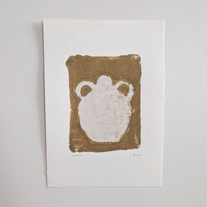 May include: A white silhouette of a vase with two handles is printed on a brown background. The print is titled "monoprint" and numbered "2 of 100".