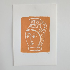 May include: A white line drawing of a pitcher with a face on a burnt orange background. The text "monotype" and "Picasso Jug 2" are printed below the pitcher. The number "4/10" is printed in the bottom right corner.