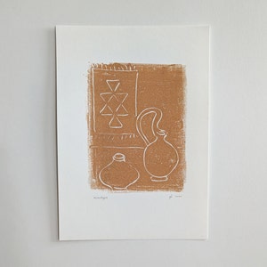 May include: A brown and white linocut print of a still life with a patterned rug, a pitcher, and a vase. The print is signed and dated "moonkyte 2020".
