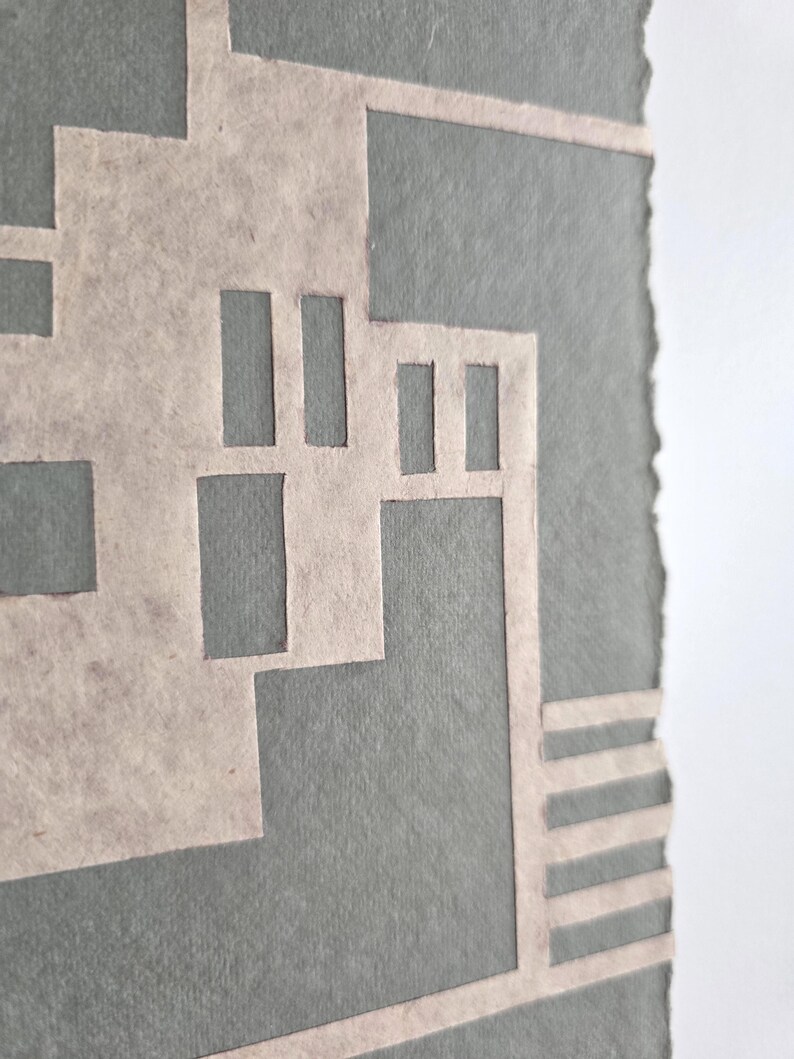 Puede incluir: Obra de arte abstracta con un dise&ntilde;o geom&eacute;trico en beige claro sobre un fondo gris. La obra tiene una apariencia texturizada y un borde rasgado. El dise&ntilde;o incorpora formas rectangulares y lineales.
