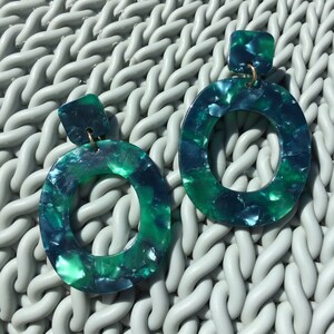 green marble acrylic statement earrings on green rattan background