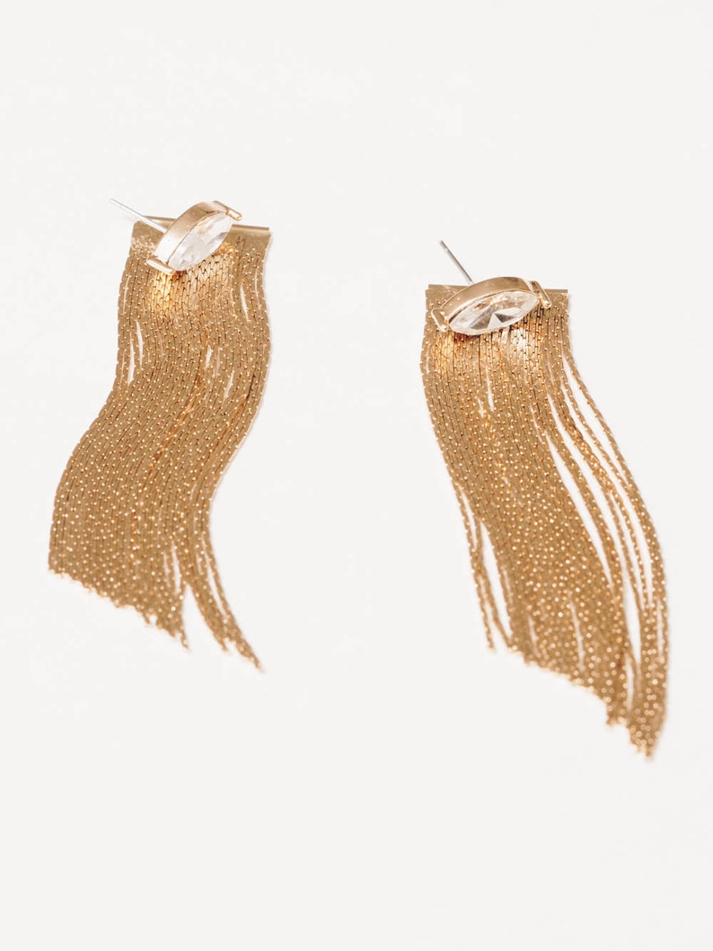 closeup of gold chain fringe crystal stud earring jackets on white background
