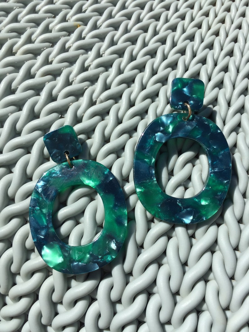 green marble acrylic statement earrings on green rattan background