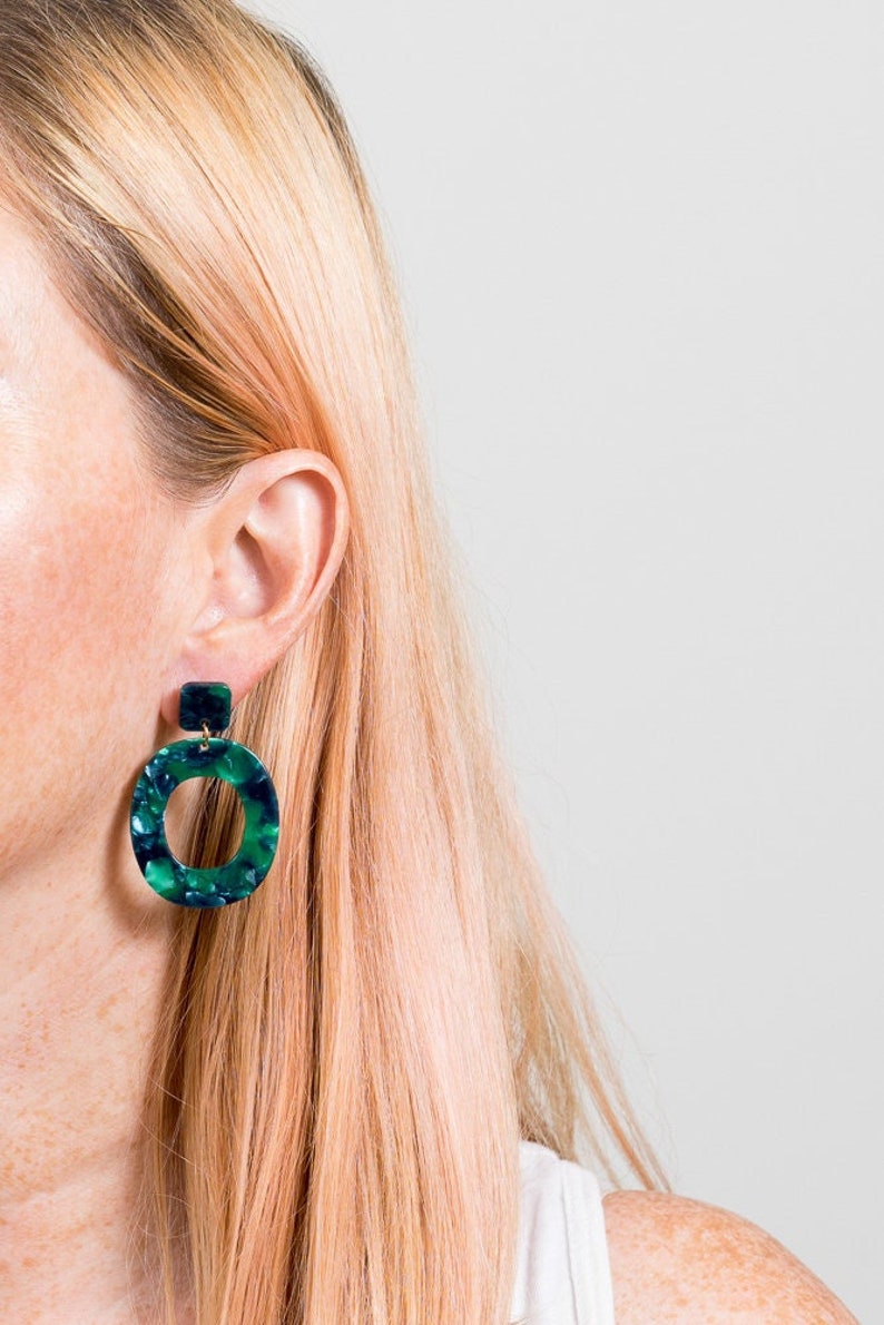 green acrylic statement earrings on pink haired model