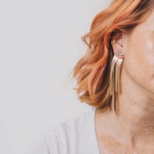 gold chain fringe earring jacket earrings with crystal marquis stud on pink haired freckled model in white t shirt on white background