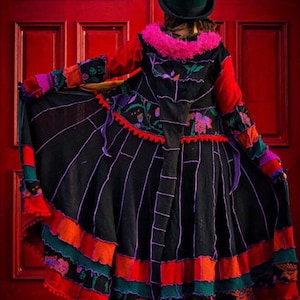 May include: A vibrant patchwork coat and skirt. The black skirt has vertical lines and colourful trim in red, orange, green, and purple. The coat features a red bodice, floral details, and a pink fur collar. A green top hat completes the outfit.