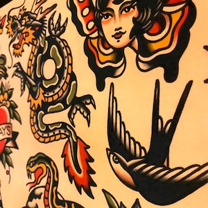 May include: A traditional tattoo flash sheet with a variety of colorful designs, including a green dragon, a black and white swallow, a red heart with flowers, a snake, and a woman with butterfly wings.