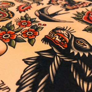 May include: A traditional tattoo flash sheet with a black wolf head, a red rose, a swallow, a skull with a snake, and a banner with the text "Unison".