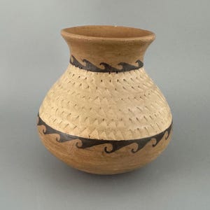 May include: A handcrafted, earthenware vase with a rounded body and a flared rim. The vase features a textured, light tan central band, framed by dark brown wave patterns. The top and bottom sections are a darker brown.