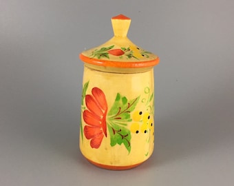 May include: A small, hand-painted wooden jar with a lid. The jar is yellow with orange, red, and green floral designs.