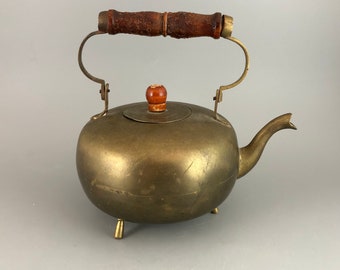 Tetera antigua de latón con asa y pomo de madera.