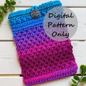 Könnte beinhalten: Gehäkelte Hülle in einem Farbverlauf von Blau, Lila und Rosa. Der obere Rand ist blau mit einem dekorativen Knopfverschluss. Der Text "Digital Pattern Only" ist auf dem Bild überlagert. Die Hülle besteht aus einem strukturierten Stich.