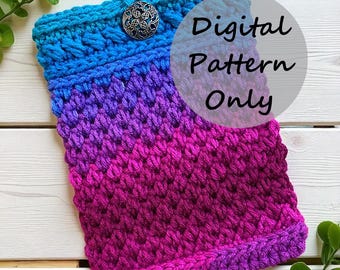May include: A crocheted sleeve in a gradient of blue, purple, and pink hues. The top edge is blue with a decorative button closure. The text "Digital Pattern Only" is overlaid on the image. The sleeve is made of a textured stitch.