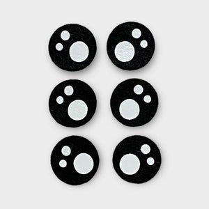 May include: Six black round stickers with white circles and dots in the centre.