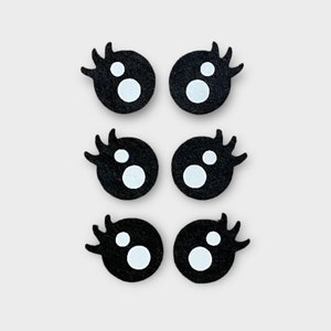 May include: Six black felt googly eyes with white pupils. Each eye has eyelashes.