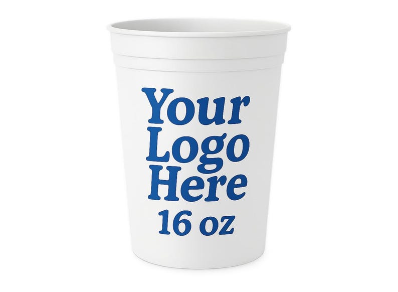 May include: A white plastic cup with a blue logo and text that reads "Your Logo Here" and "16 oz". The cup is cylindrical with a slightly flared top and horizontal ridges near the top.