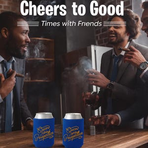 May include: Image of three men in suits enjoying cigars and drinks. Two blue can coolers with gold text that reads "Soon Away Perspective" are on the wooden bar. The text "Cheers to Good Times with Friends" is at the top of the image.
