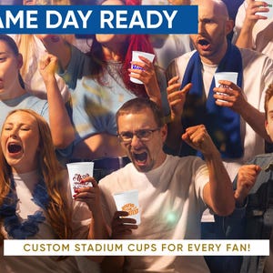 May include: A crowd of excited fans at a sporting event, holding white stadium cups. The cups have custom designs and text. The words "GAME DAY READY" and "CUSTOM STADIUM CUPS FOR EVERY FAN!" are displayed.
