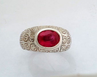 Dress Ring in Sterling Silver, with a Faceted Ruby and  Spiral patterned design.
