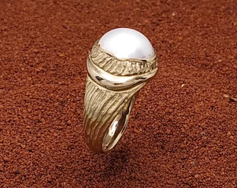 Mabe pearl signet ring with a hand carved design. In solid 9 k gold.