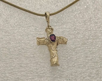 Crucifix pendant solid 9 k gold with raised carved design and set with a central buff-cut, oval  Pink Tourmaline.