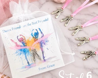 May include: A set of six silver-toned ballet slipper charms attached to pink satin ribbons, presented with a white card featuring a watercolor illustration of two dancers and the text Dance Friends are the Best Friends! and From: Grace.