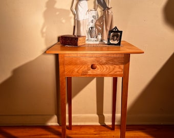 Cherry side table. Tapered legs and table top lighten the look for a graceful appearance. Mortise and tenon joinery. Hand-cut dovetails.